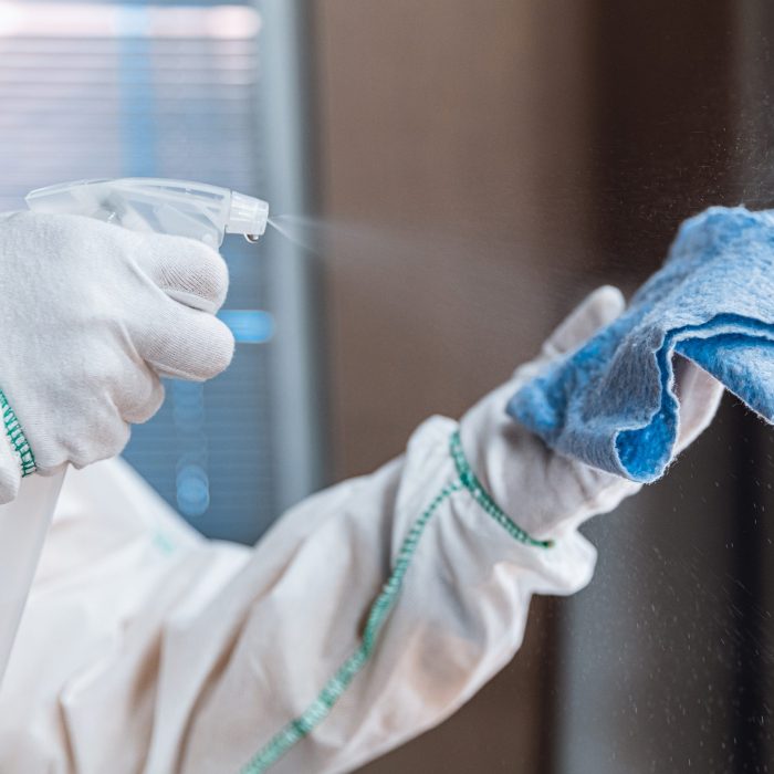 Coronavirus Pandemic. A disinfector in a protective suit and mask sprays disinfectants in house or office. Protection against COVID-19 disease. Prevention of spreding pneumonia virus with surfaces.